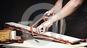 Carpenter Working in Woodworking Workshop. Sawing Planks of Wood