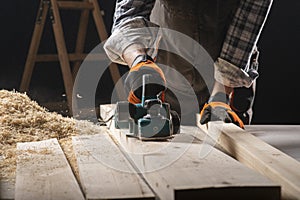 Carpenter works with electrical planer