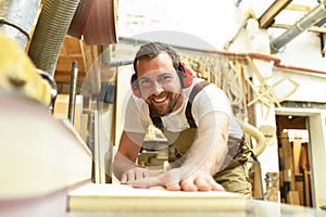 carpenter works in a joinery - workshop for woodworking and sawing photo