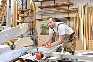 carpenter works in a joinery - workshop for woodworking and sawing