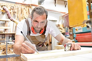 carpenter works in a joinery - workshop for woodworking and sawing