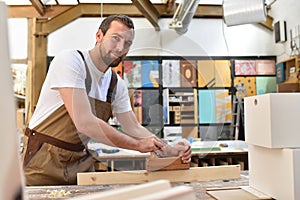 carpenter works in a joinery - workshop for woodworking and sawing