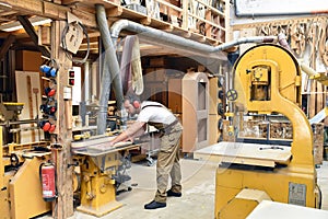 carpenter works in a joinery - workshop for woodworking and sawing