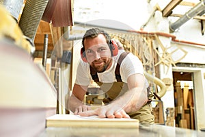 carpenter works in a joinery - workshop for woodworking and sawing