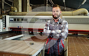 Carpenter works on wood plank in carpentry workshop
