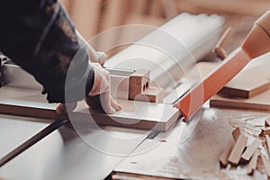 A carpenter works on woodworking the machine tool. Carpenter working on woodworking machines in carpentry shop.