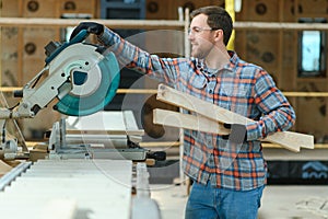 A carpenter works on woodworking the machine tool. Man collects furniture boxes. Saws furniture details with a circular