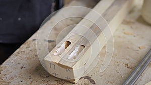 A carpenter in the workshop lubricates furniture parts with glue in the workshop. Processes wood for the manufacture of