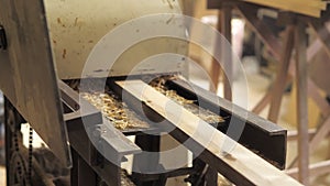 A carpenter in the workshop works on a woodworking machine, processes and aligns wood for the manufacture of furniture