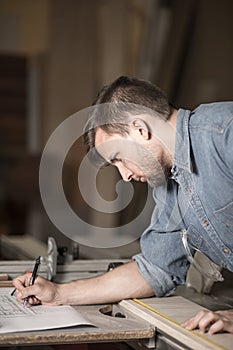 Carpenter writing down measurements