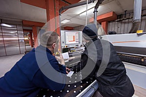 Carpenters calculating and programming a cnc wood working machine