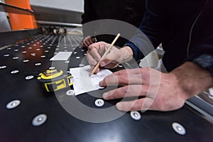 Carpenters calculating and programming a cnc wood working machine