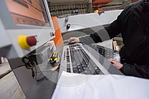 Carpenters calculating and programming a cnc wood working machine