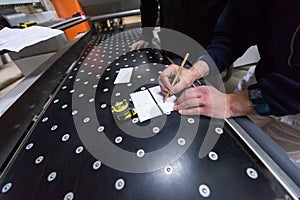 Carpenters calculating and programming a cnc wood working machine