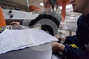 Carpenters calculating and programming a cnc wood working machine