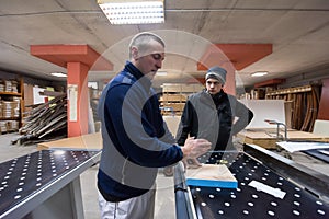 Carpenters calculating and programming a cnc wood working machine