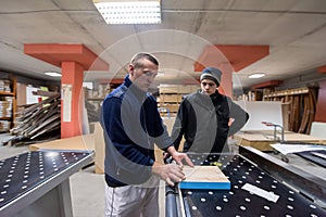 Carpenters calculating and programming a cnc wood working machine