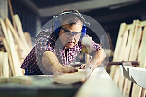 Carpenters cutting wooden plank with a circular saw photo