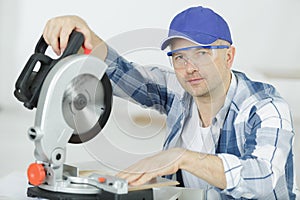 Carpenters cutting wooden plank with circular saw