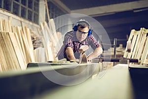 Carpenters cutting wooden plank with a circular saw photo