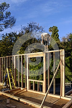 Carpenters framing a new exterior wall on deck