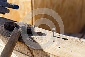 Carpenters uses a hammer to driving nail, Craftsmen and builder equipment. A man hammers an iron nail into a wooden beam