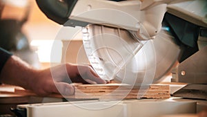 Carpentry industry - man cutting out the piece of wood using big circular saw