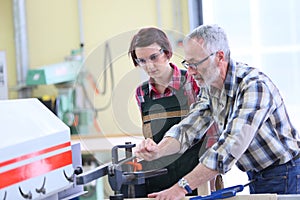 Carpentry professor teaching young woman apprentice