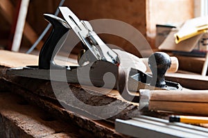 Carpentry tools on wood boards, focus on the plane