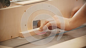 Carpentry working - hands of man worker make a hemisphere cutout in the plywood