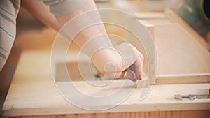 Carpentry working - hands of man worker moving the plywood to other wooden items