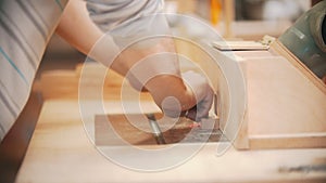 Carpentry working - hands of man worker polishing the plywood