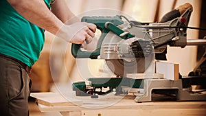 Carpentry working - man cutting out the piece of wood using big circular saw