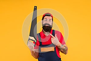 Carpentry workshop concept. Professional tools. Builder worker carpenter handyman hold saw yellow background. Man hold