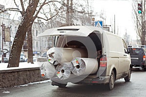 Carpet delivery van with open trunk. Large bulky cargo transportation. Carpeting cleaning and delivery concept photo