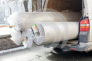 Carpet delivery van with open trunk. Large bulky cargo transportation. Carpeting sale and delivery concept