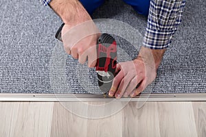 Carpet Fitter Installing Carpet With Wireless Screwdriver