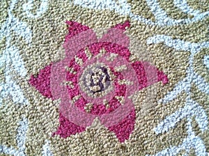 Carpet texture with a pink flower in the center photo