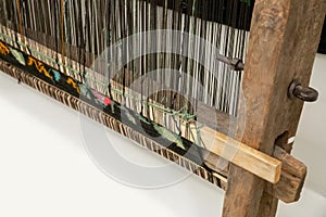 Carpet weaving, traditional hand loom on white background. Close-up