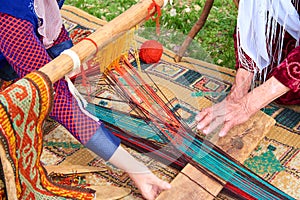 Carpet weaving. Woman hands weaving carpet on the loom.