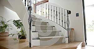 Carpeted spiral staircase and pants in light hallway of luxury home, copy space, slow motion