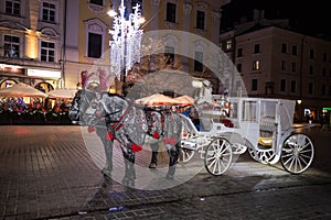 A carriage with horses. Christmas square. Krakow. Celebration. Night fair. Feast of approaching