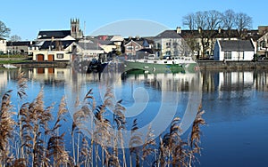 Carrick-on-Shannon, County Leitrim, Ireland viewed from across River Shannon against backdrop of blue sky on winter day