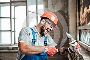 Carried away by work builder strikes with a hammer, screaming