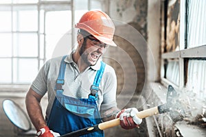 Carried away by work contractor strikes with a big hammer, hardly screaming