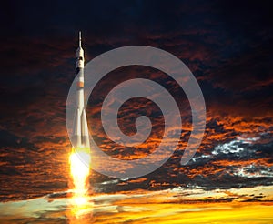Carrier Rocket On A Background Of Red Clouds