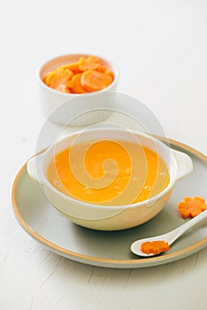 Carrot baby puree in bowl isolated on light background