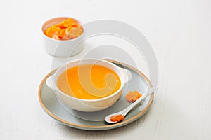 Carrot baby puree in bowl isolated on light background