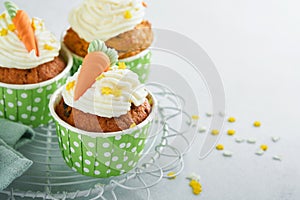 Carrot cake cupcakes for Easter. Carrot cupcakes with cream cheese frosting decorated with tiny marzipan carrots on white