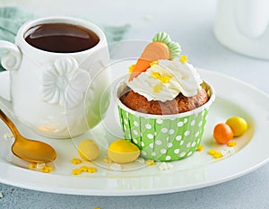 Carrot cake cupcakes for Easter. Carrot cupcakes with cream cheese frosting decorated with tiny marzipan carrots on white